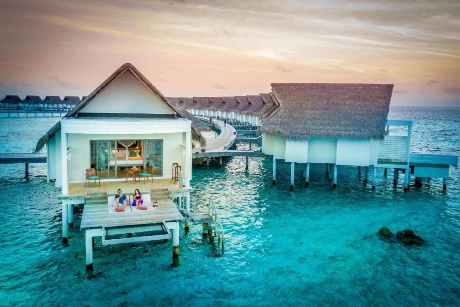 Centara Grand overwater bungalows with blue-green water and sunset sky