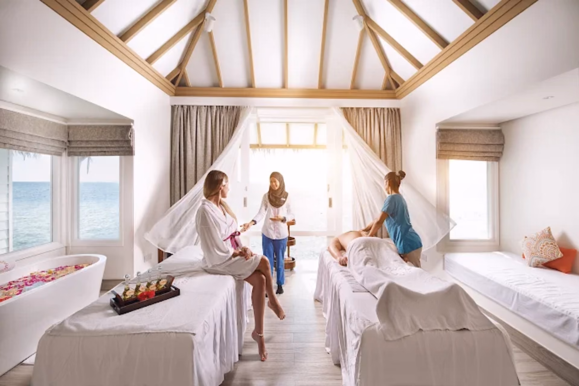Women and children in spa room at Sun Siyam Iru Veli with ocean view