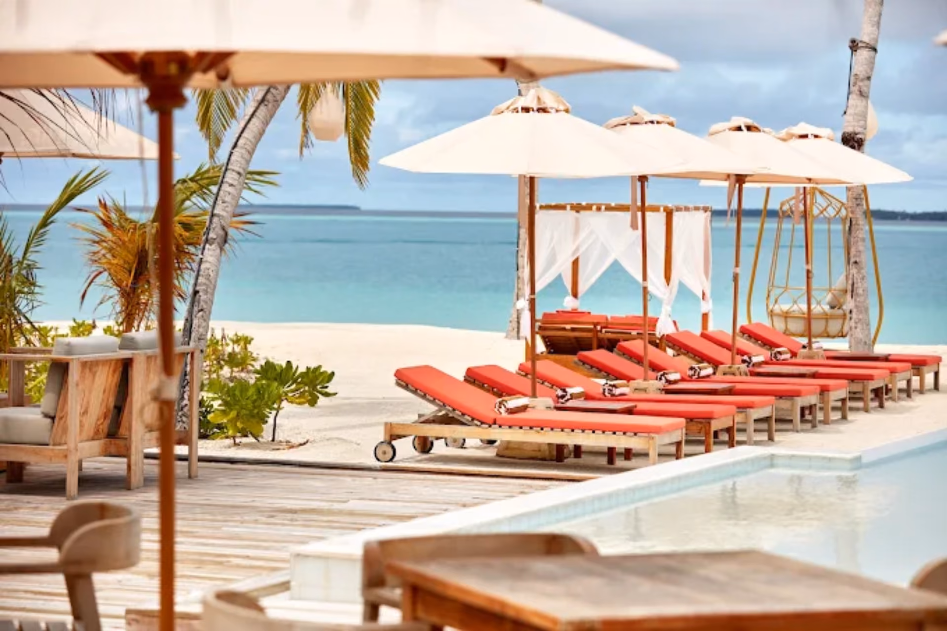 Sun Siyam Iru Veli beach with red loungers and white umbrellas