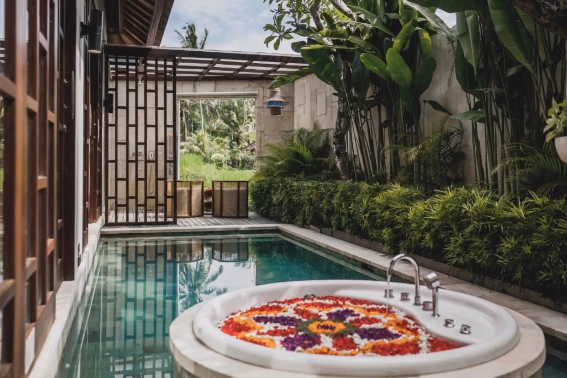 Asvara spa bath with flower petals and pool view