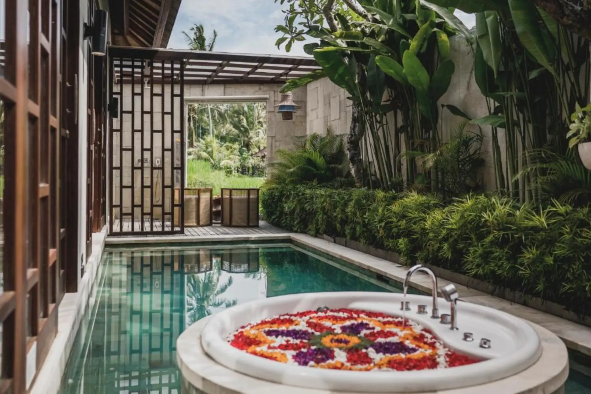 Asvara spa bath with flower petals and pool view