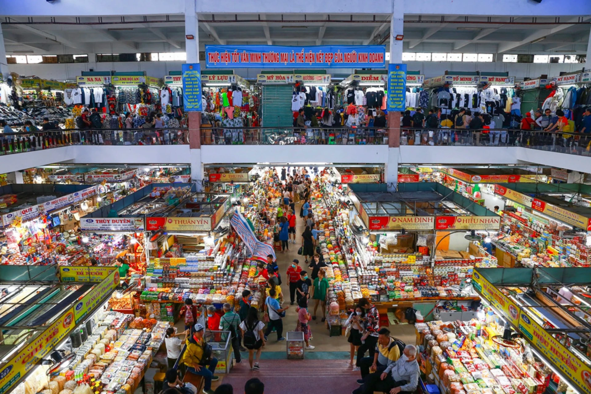 Busy indoor market with colorful stalls and shoppers at Han Market