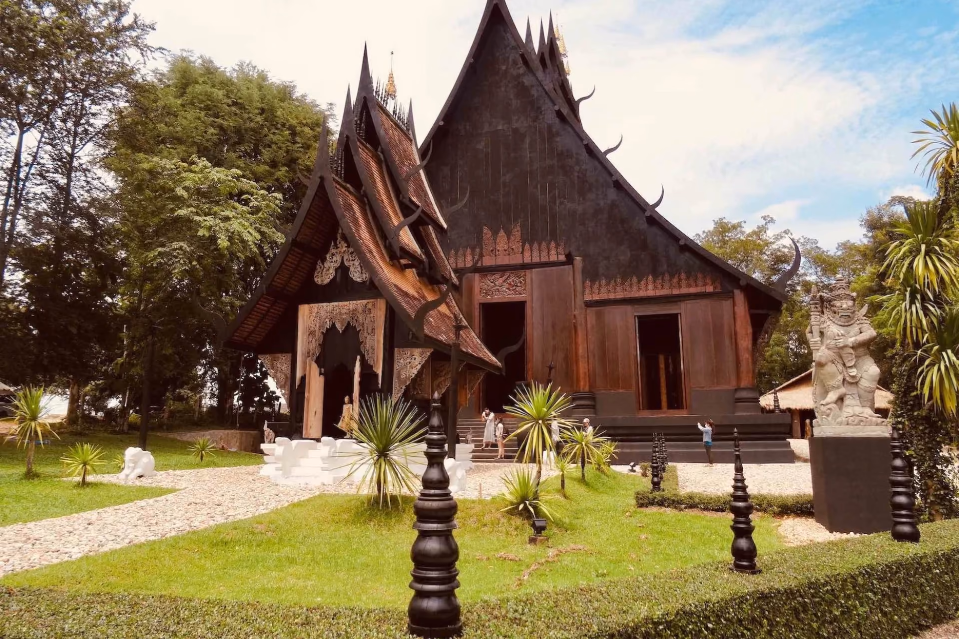 Dark wooden temple with curved roofs in Chiang Mai