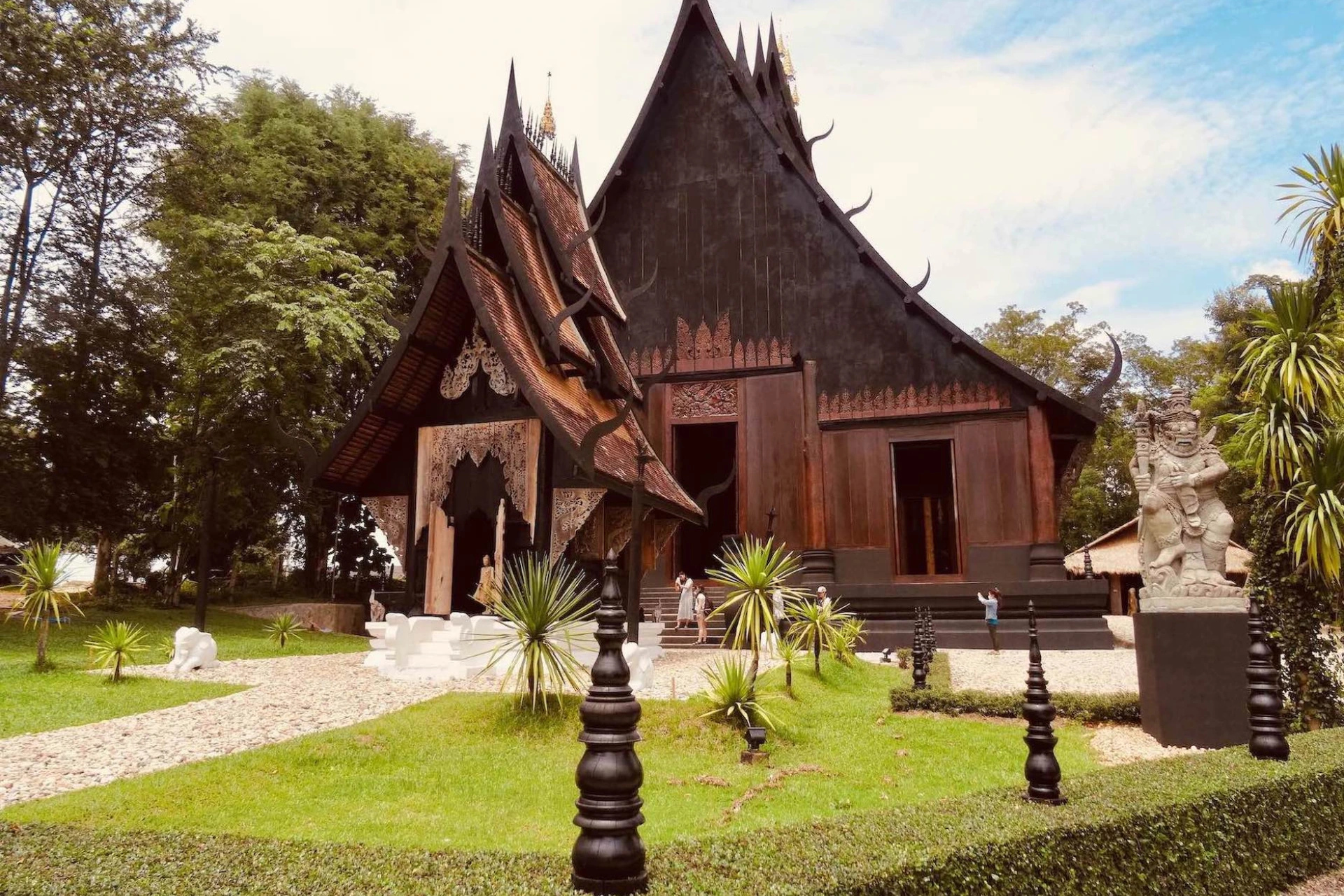 Dark wooden temple with curved roofs in Chiang Mai