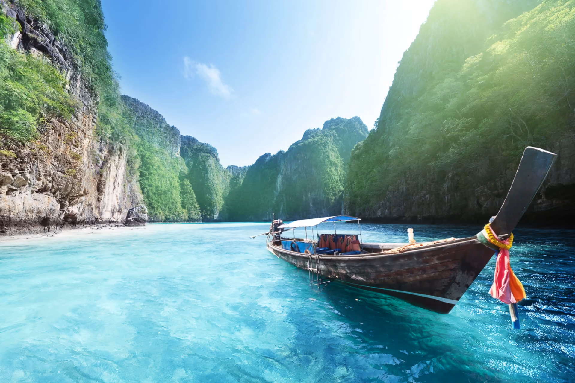 Traditional wooden boat in clear blue water, Krabi Thailand