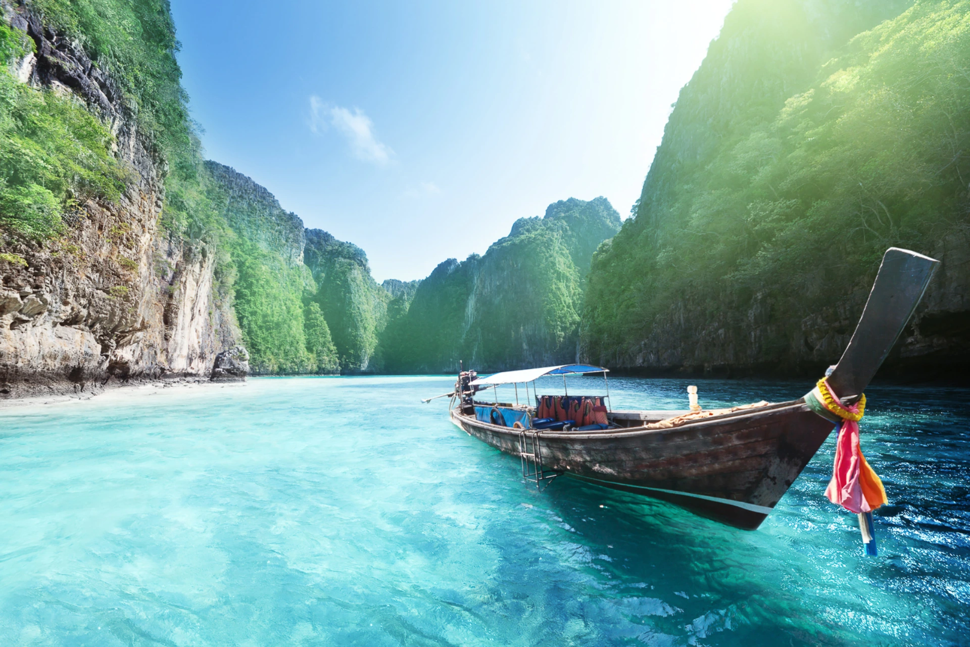 Traditional wooden boat in clear blue water, Krabi Thailand