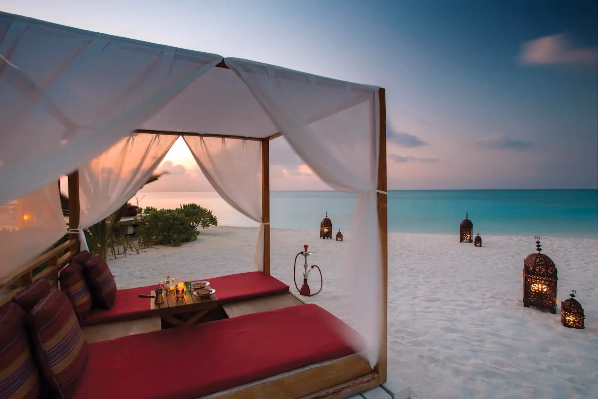 Beach bed with curtains at Atmosphere Kanifushi Resort