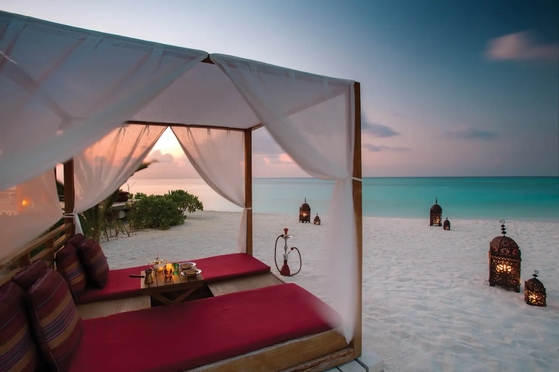 Beach bed with curtains at Atmosphere Kanifushi Resort