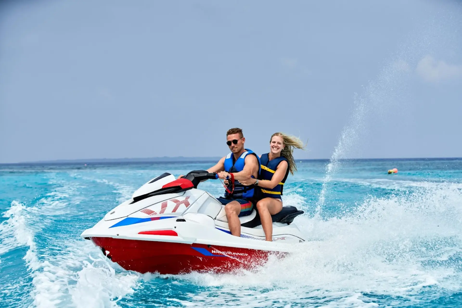 Couple jet skiing in ocean waves at Siyam World