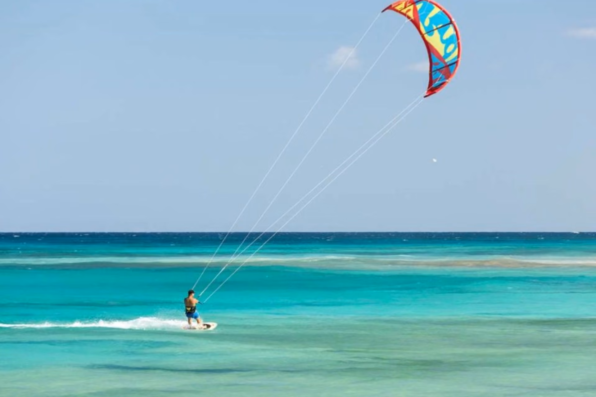 Man kitesurfing at Sun Siyam Resort in clear blue water