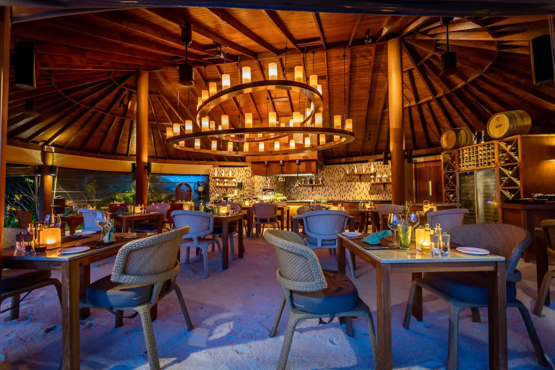 Centara Ras Restaurant with wooden roof and ocean view at dusk