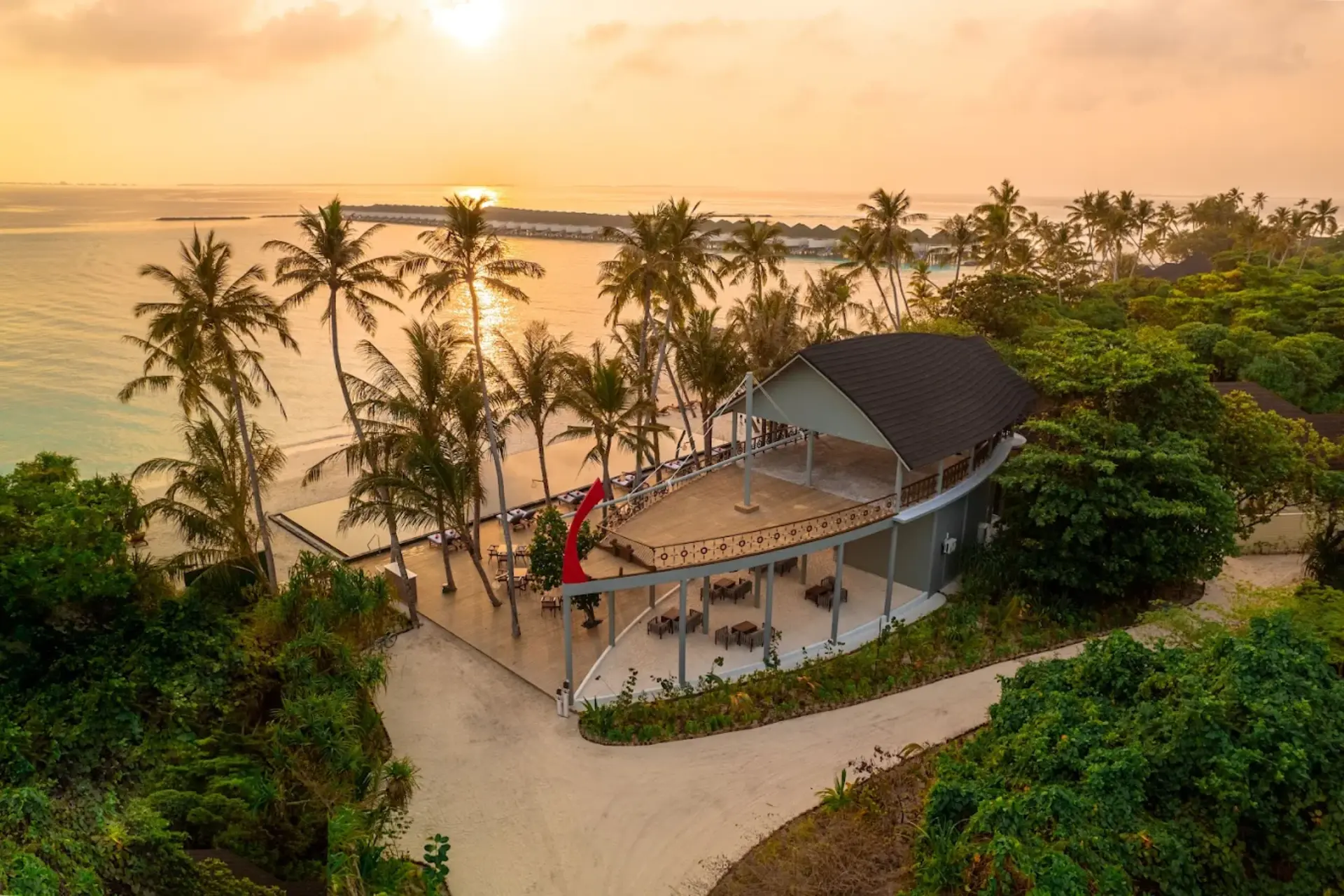 Siyam World beach resort with open shelter at sunset