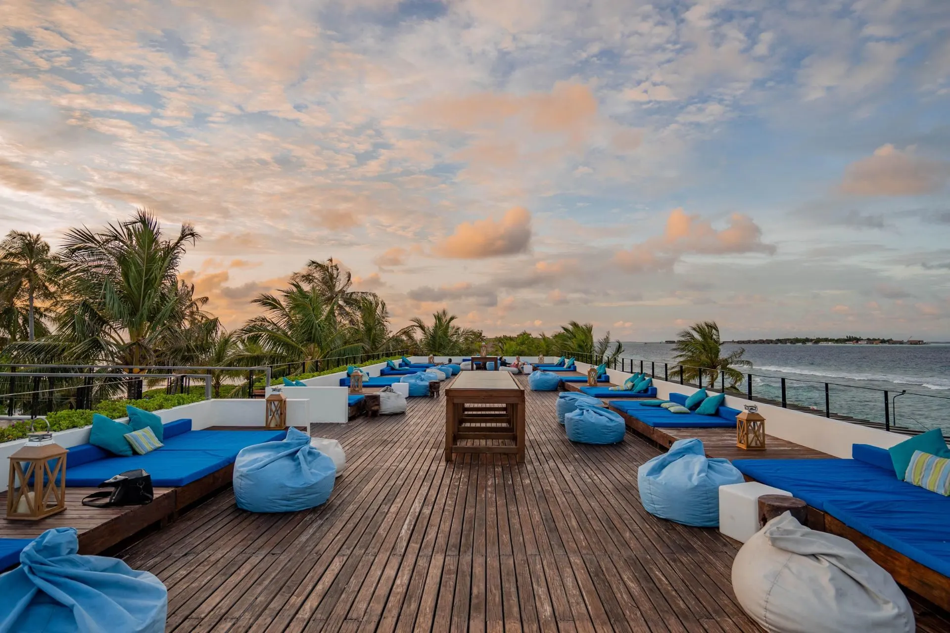 Beach resort deck with blue lounge chairs and ocean view