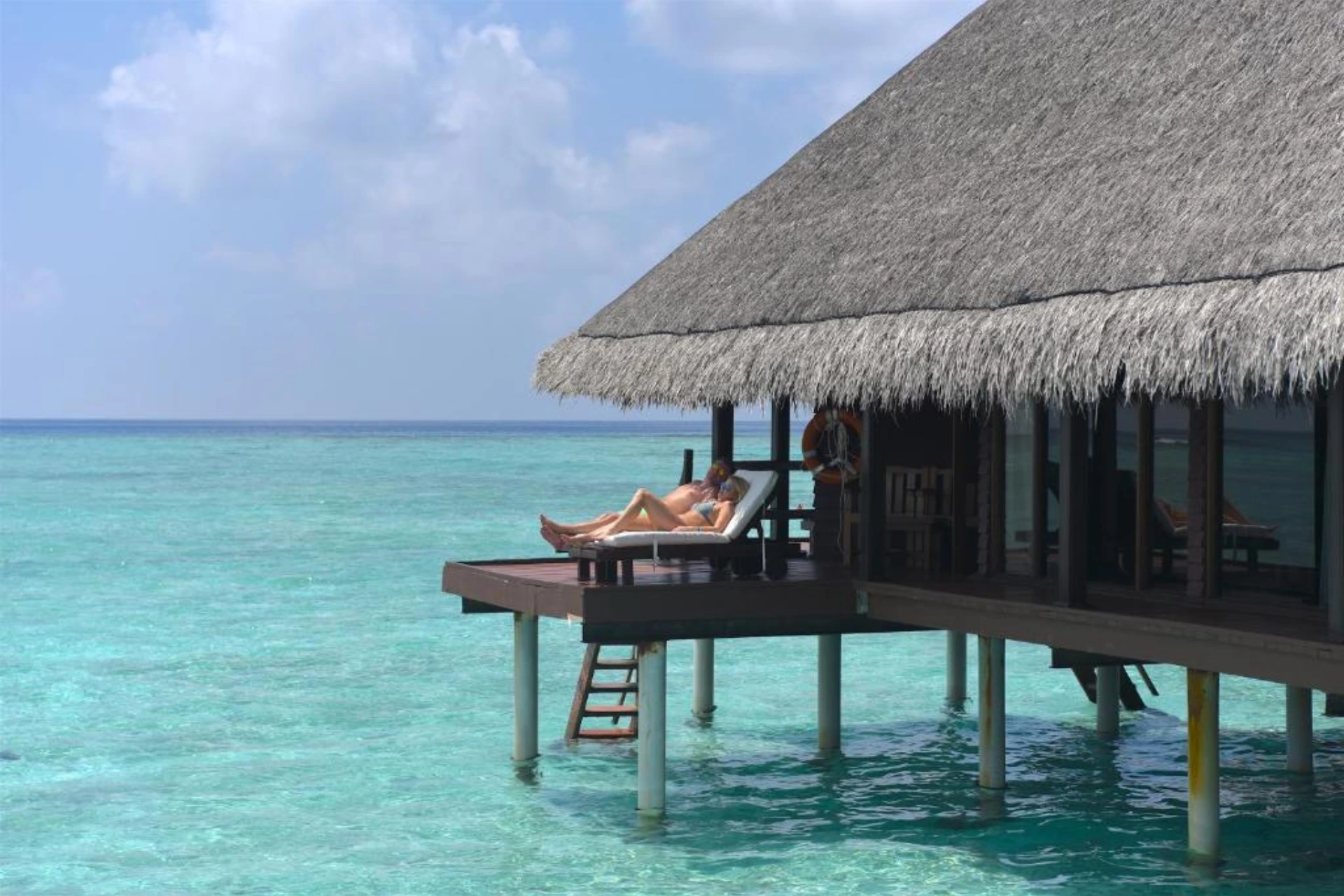 Person relaxing on deck at Adaaran Rannalhi resort