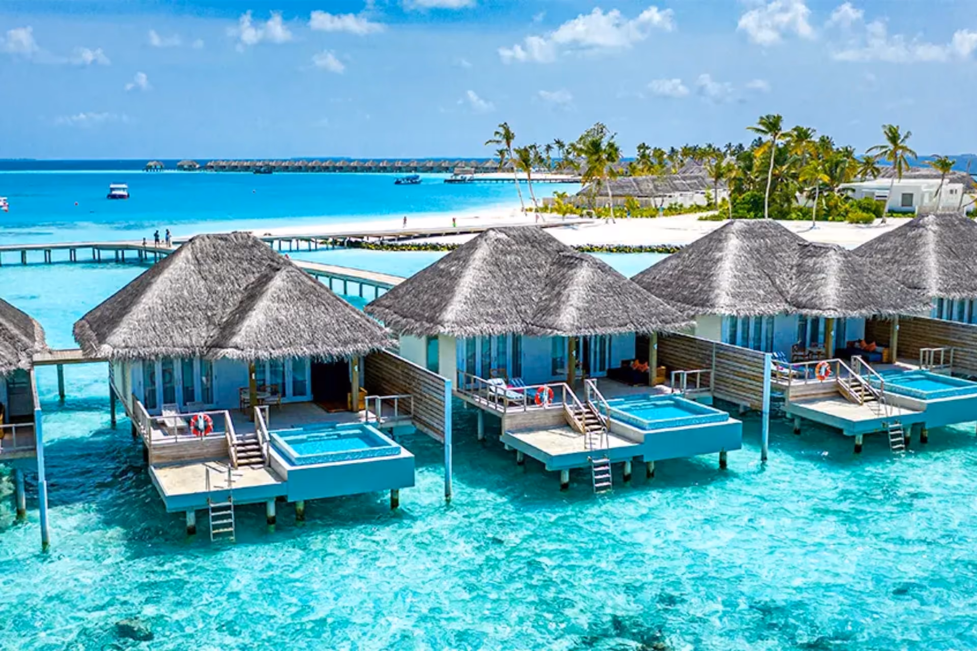 Adaaran Ranhalli water villas with thatched roofs over clear blue water