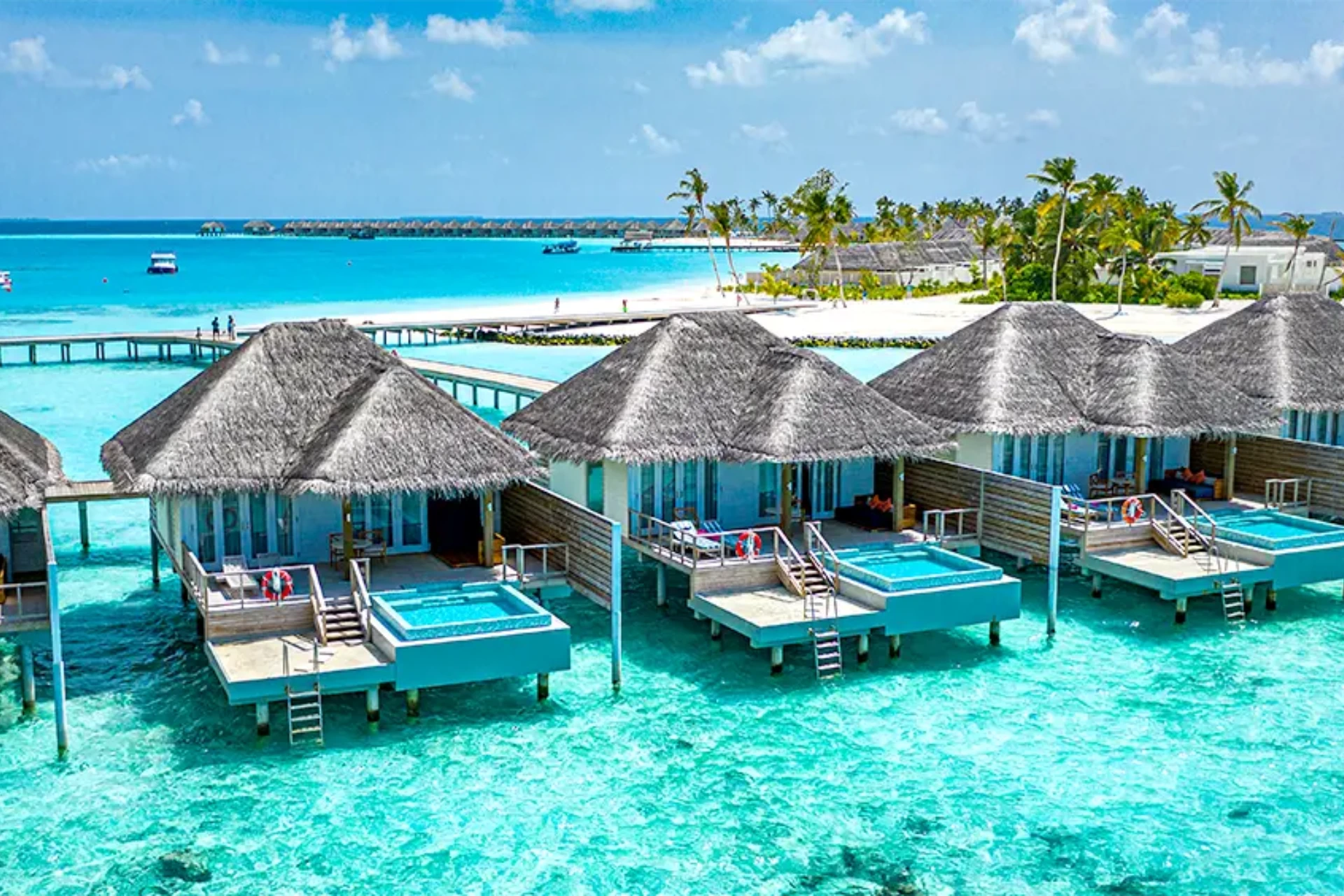 Adaaran Ranhalli water villas with thatched roofs over clear blue water