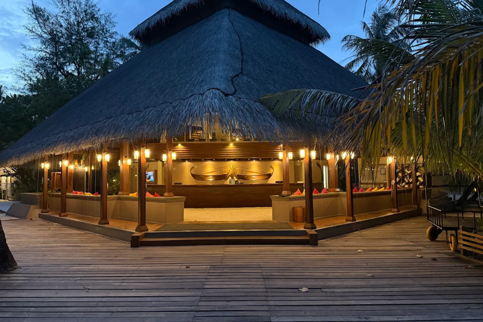 Adaaran Rannali Restaurant lit up at dusk with thatched roof