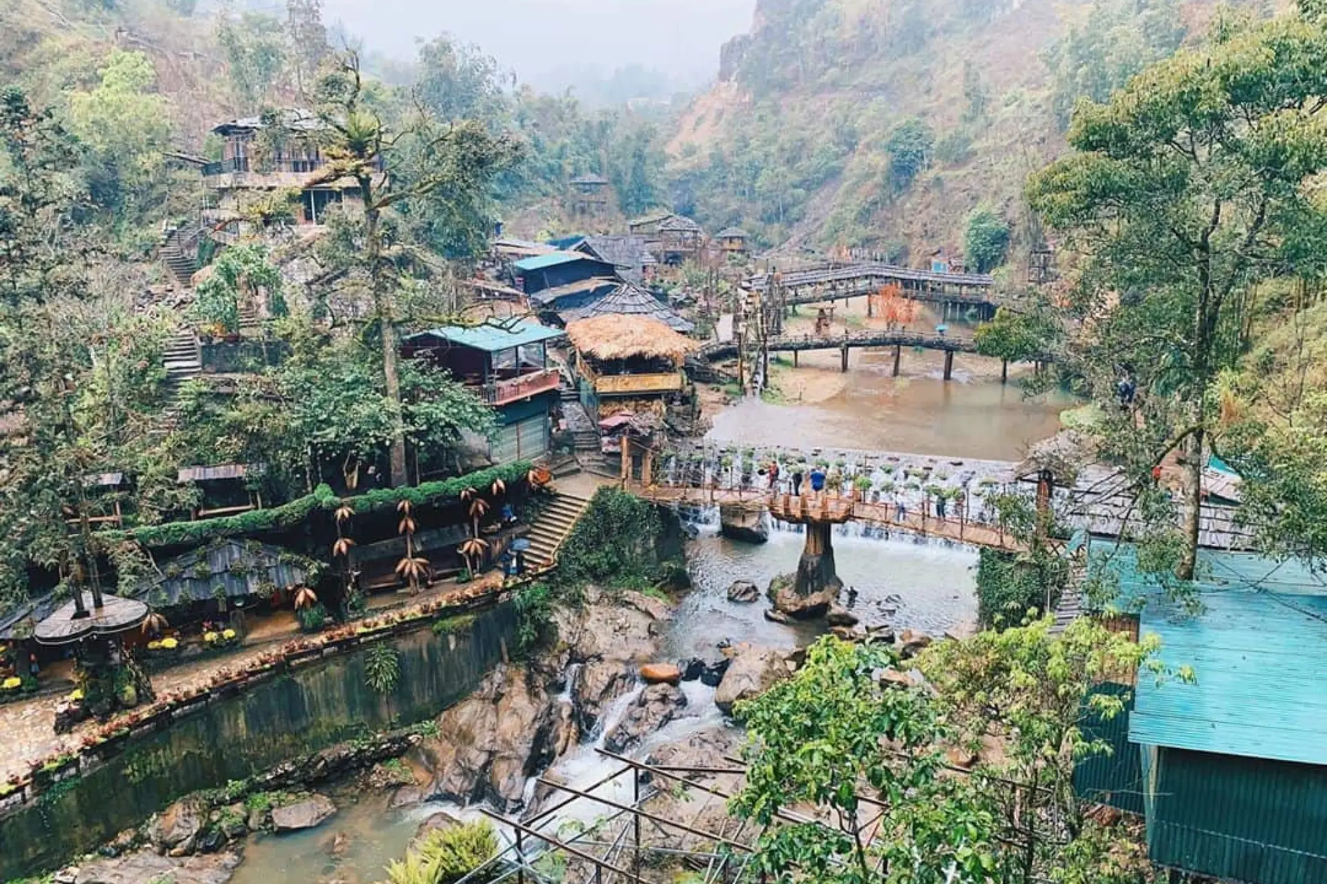 Cat Cat Village nestled in valley with wooden bridges and river