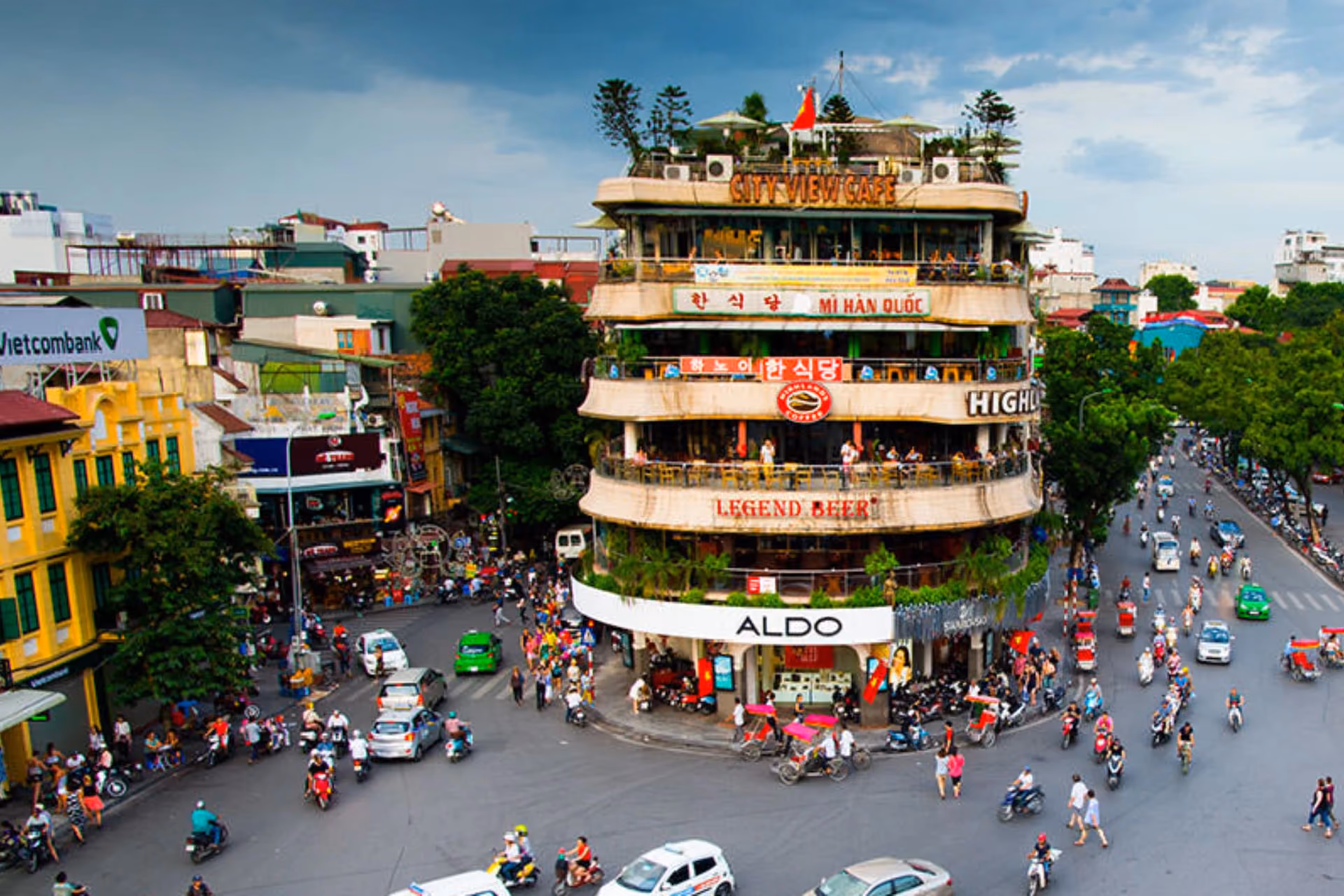 Busy street intersection in Hanoi with colorful buildings
