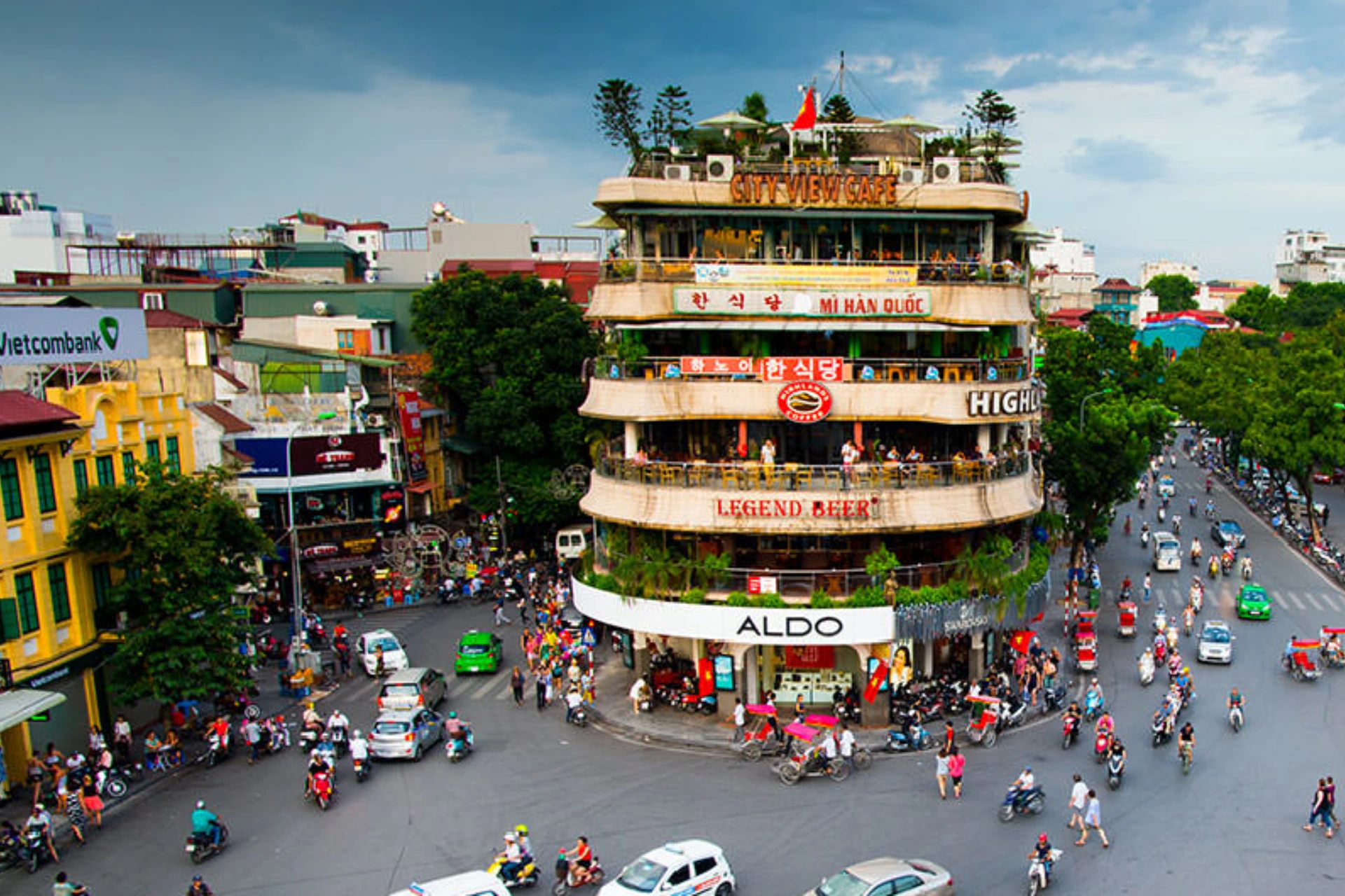 Busy street intersection in Hanoi with colorful buildings