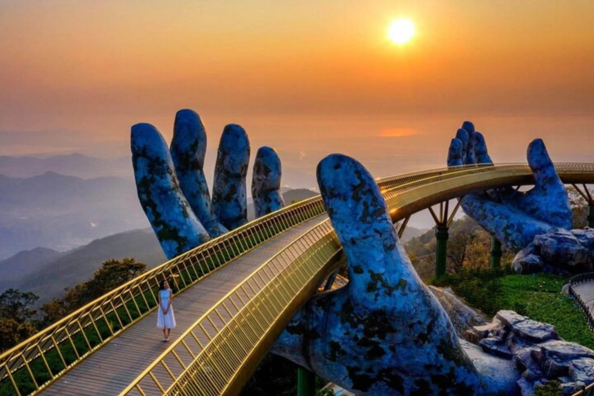 Stone hands holding Golden Bridge at sunset Vietnam