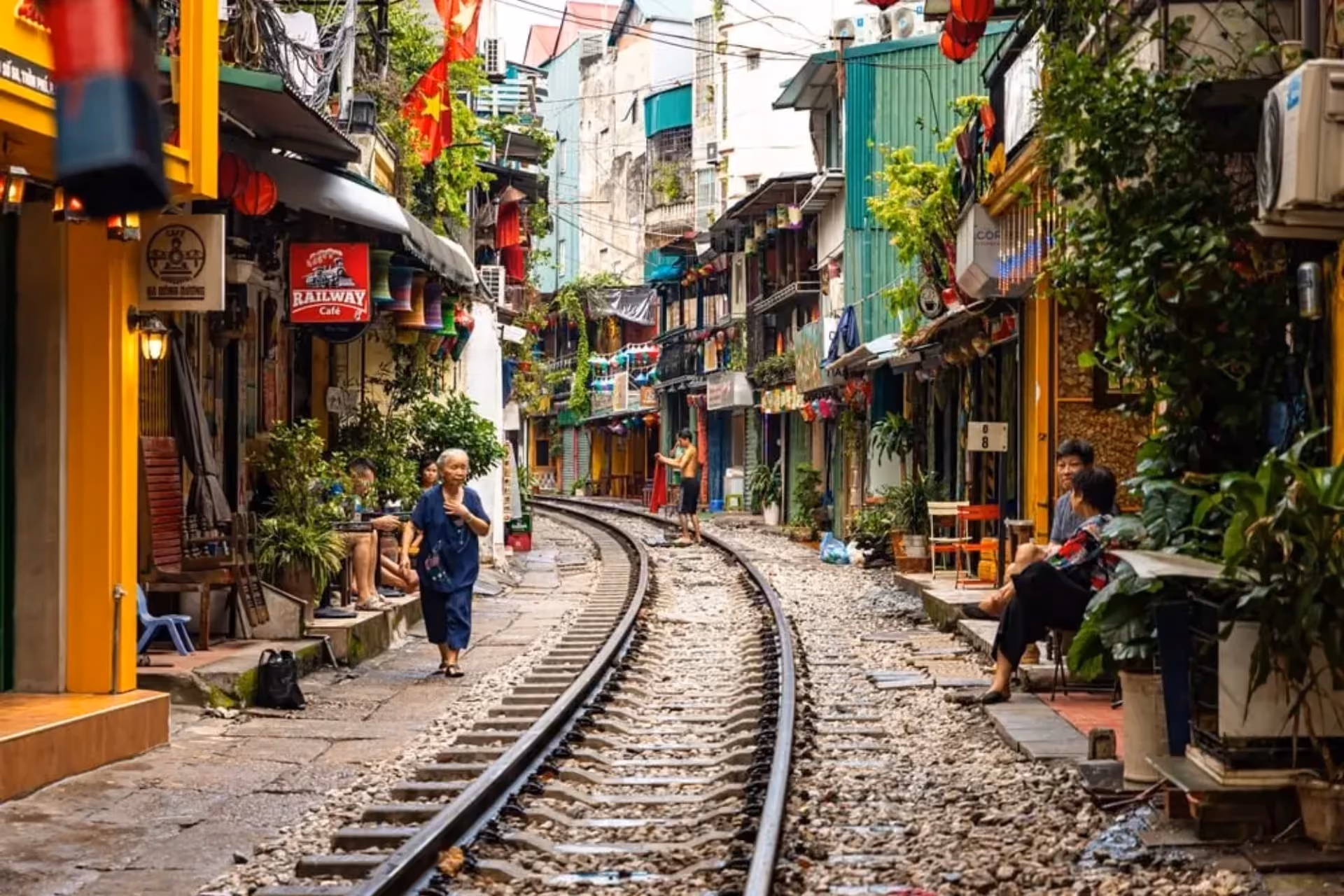 Train tracks running through colorful Hanoi street with shops