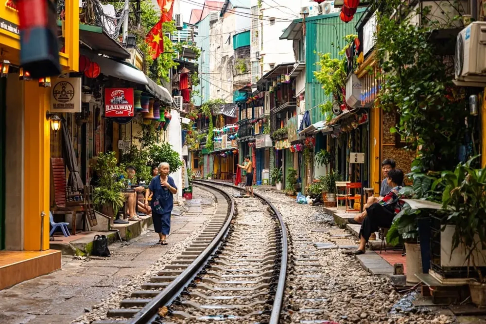 Train tracks running through colorful Hanoi street with shops