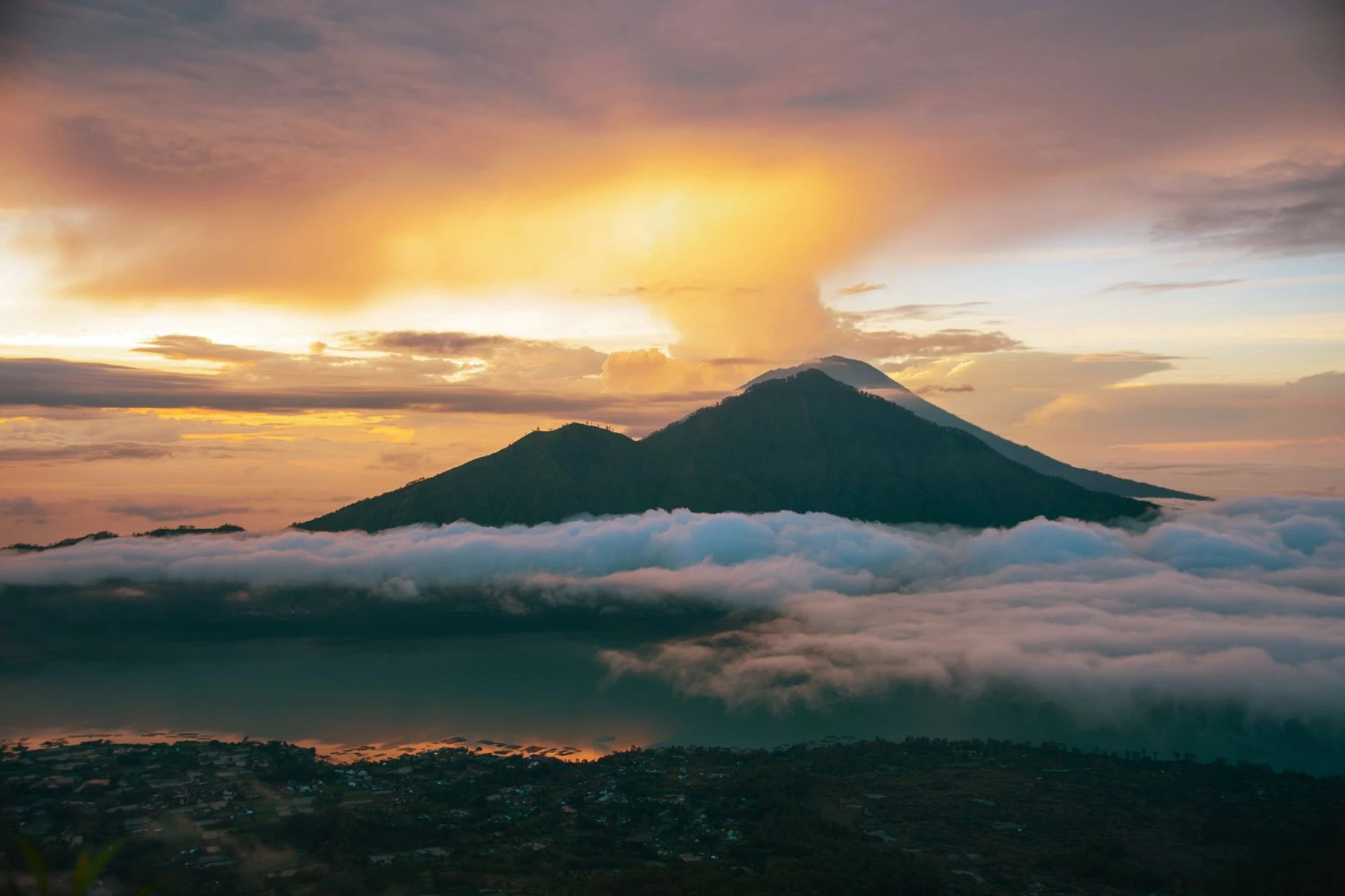 Mt Batur volcano at sunrise surrounded by clouds