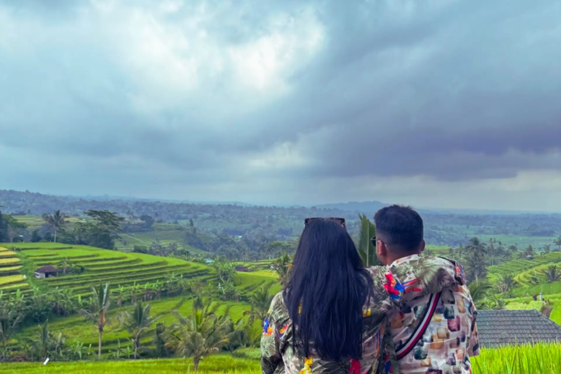 Two people looking at green rice terraces in Bali
