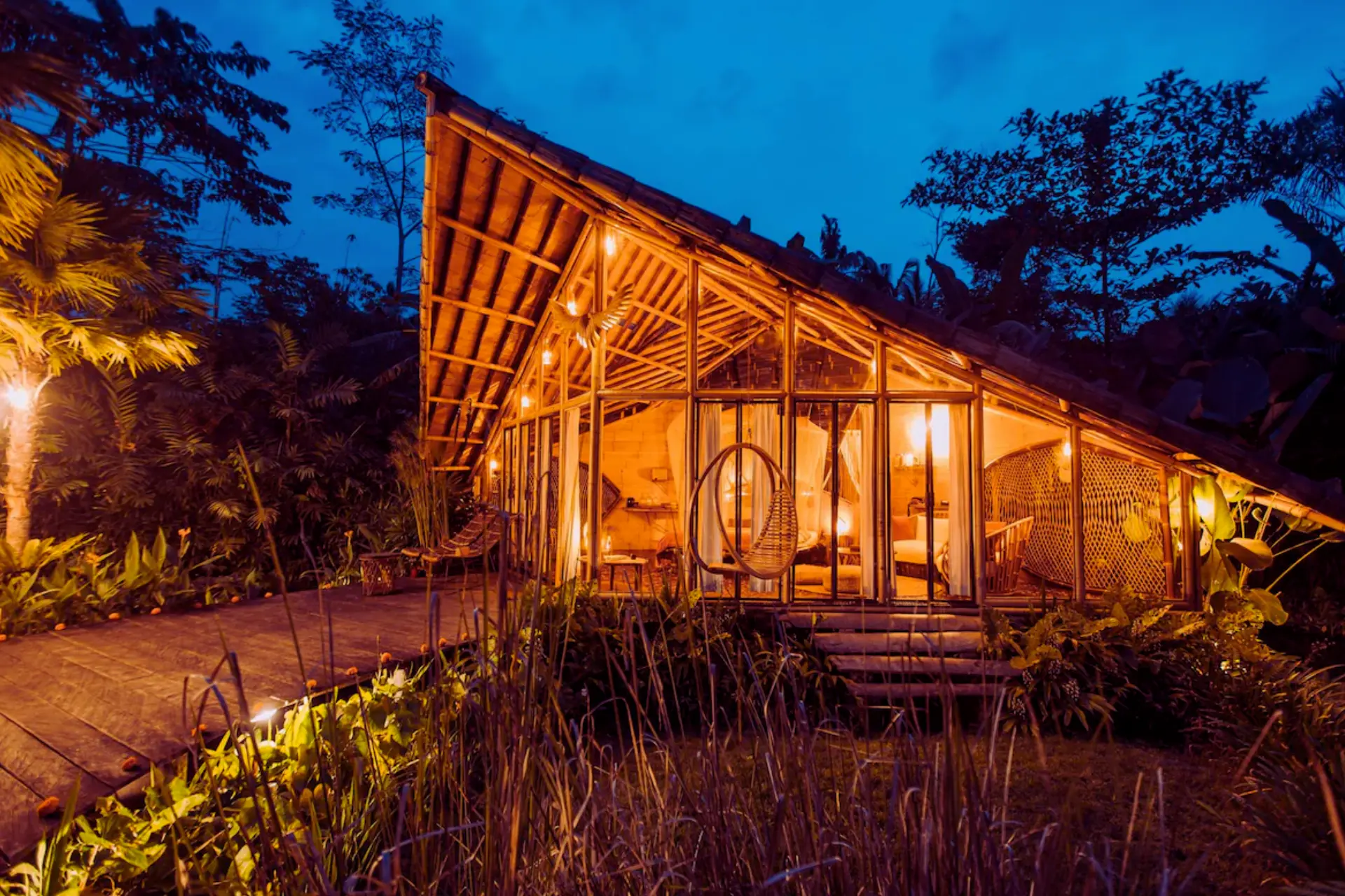 Glowing wooden tree house at night with hanging chair