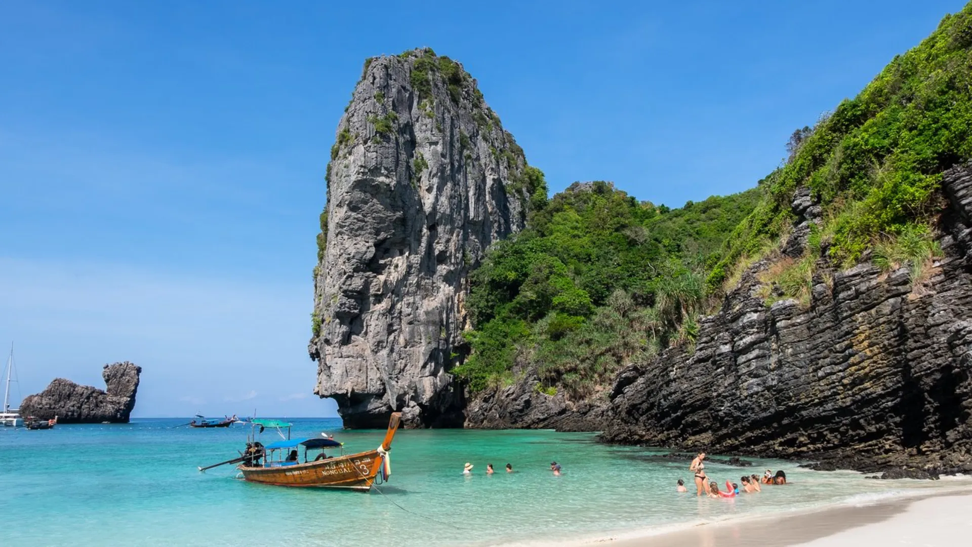Tall rock formation in clear water at Phuket beach