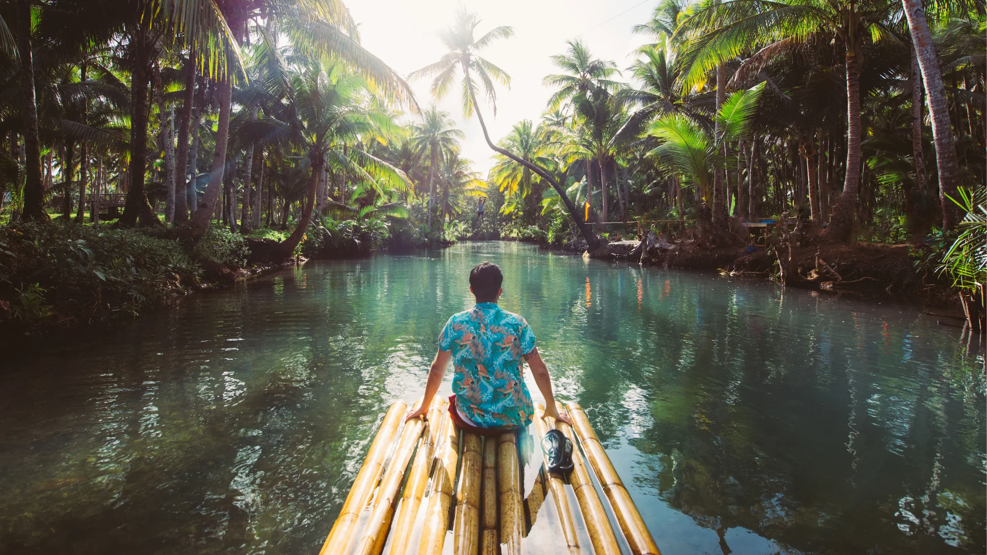 A man sitting on the edge of bamboo raft