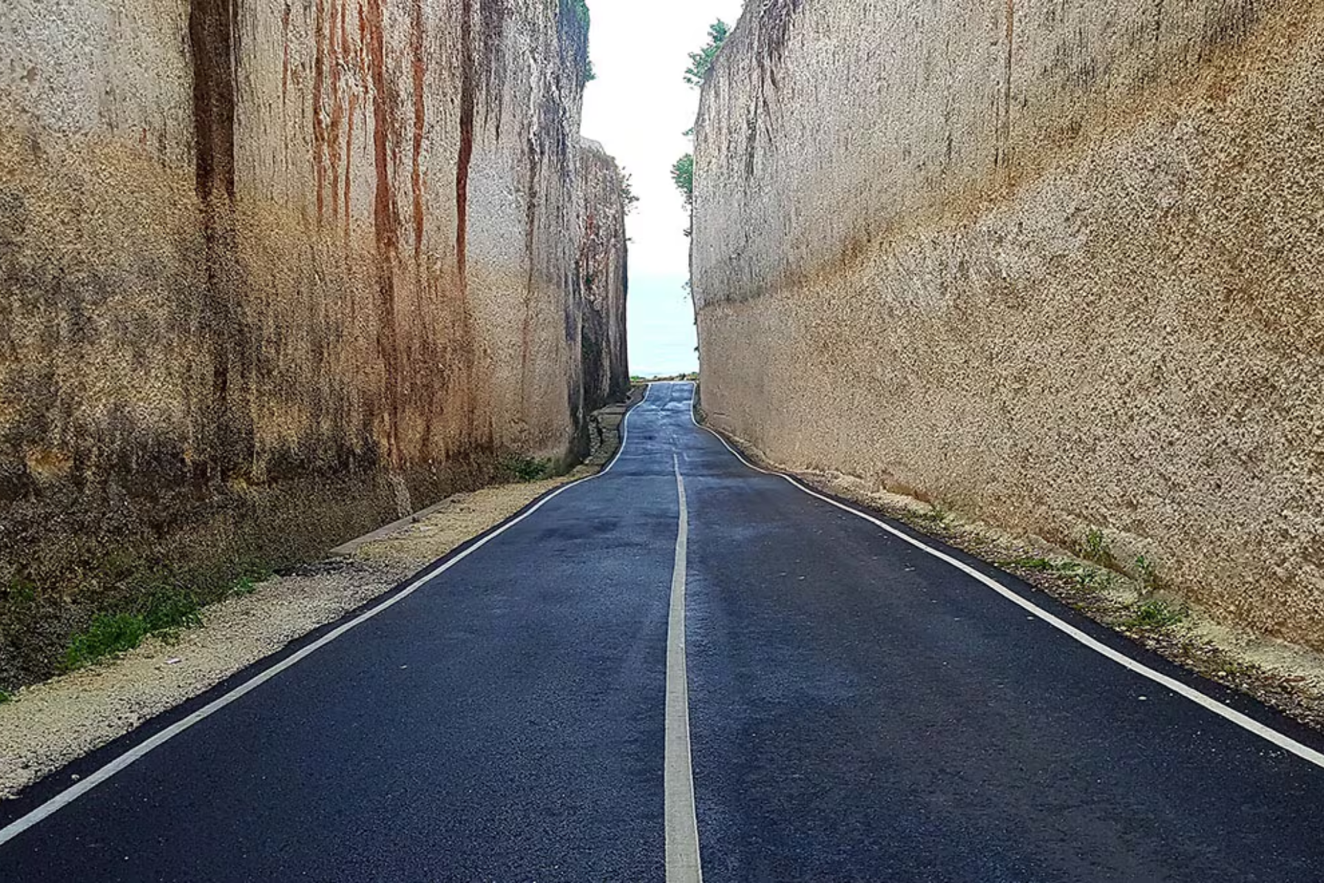 Straight road between tall stone cliffs at Pantai Batu Barak