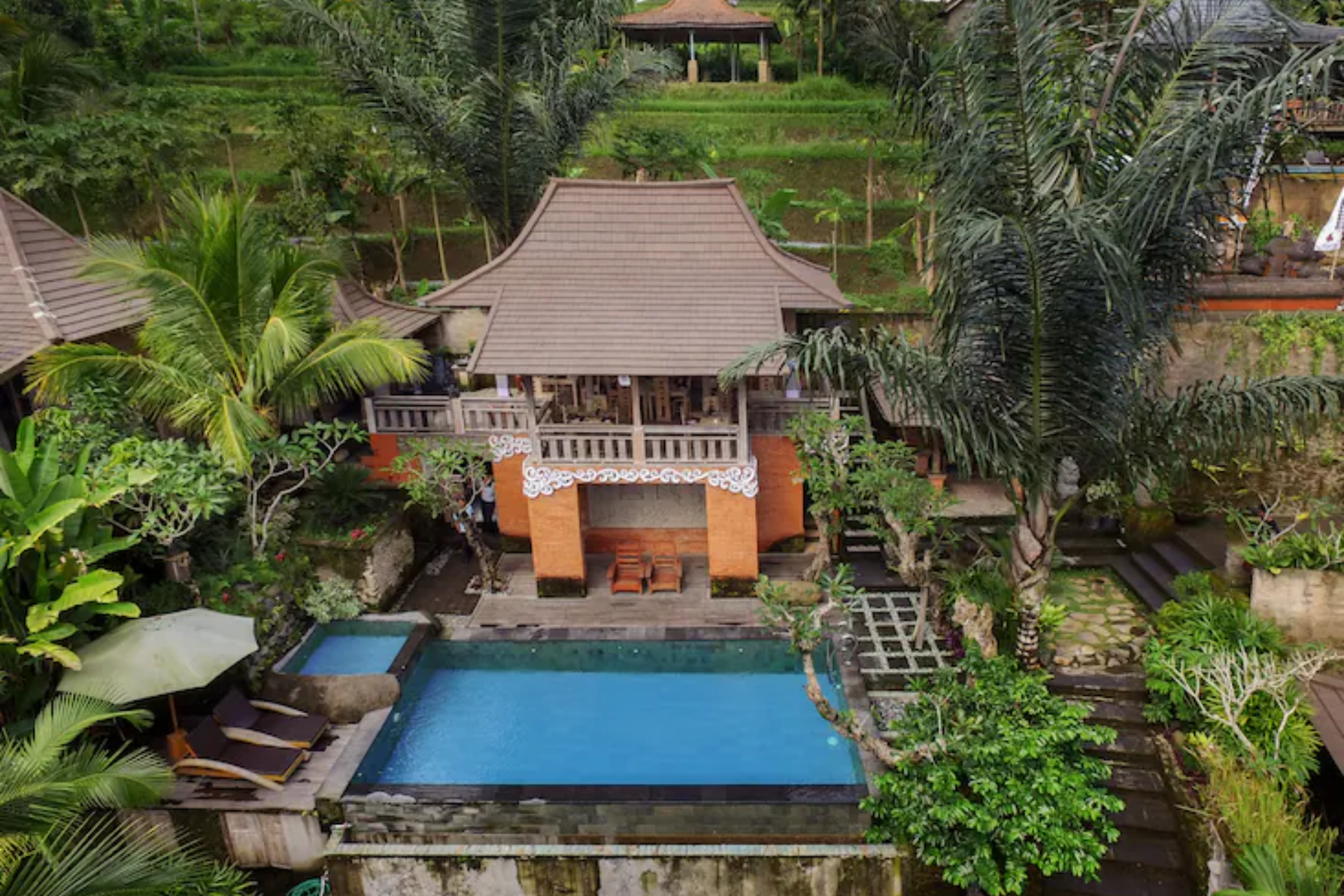 Private villa with blue pool surrounded by tropical gardens