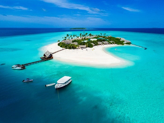 Dhigufaru Island Resort with boats in clear blue water