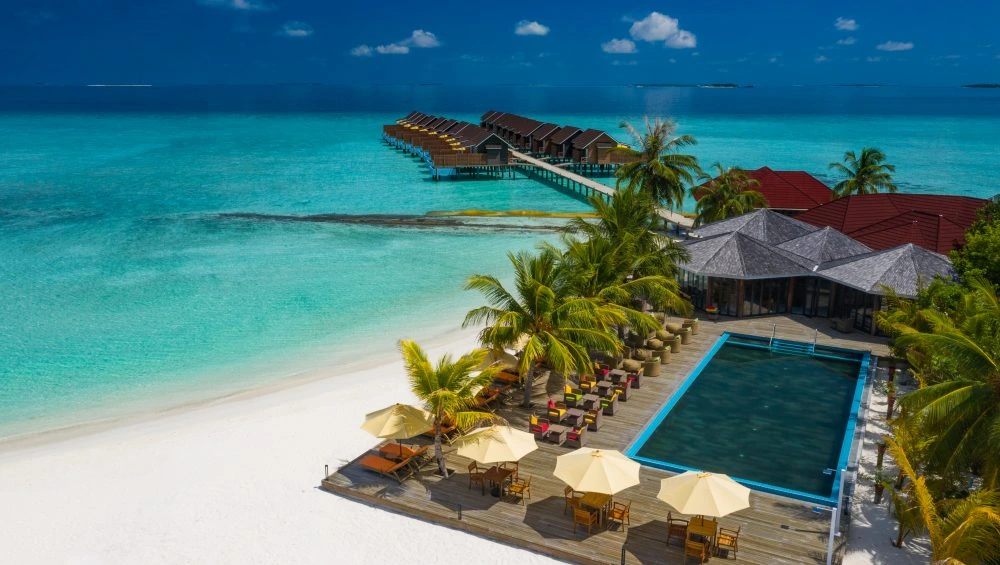 Tropical island resort with beach, pool, and water bungalows