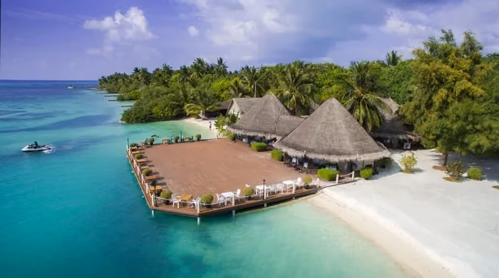 Tropical island resort with thatched roofs and clear blue water