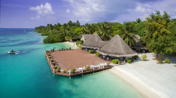 Tropical island resort with thatched roofs and clear blue water