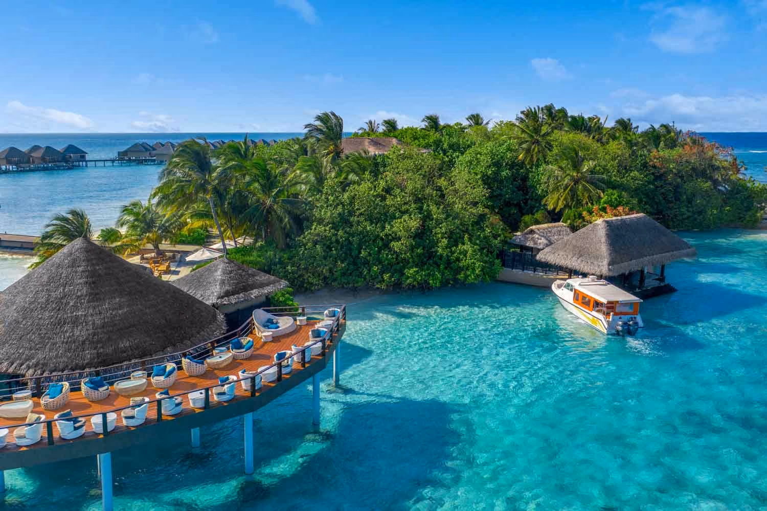 Tropical island resort with boats and thatched roofs