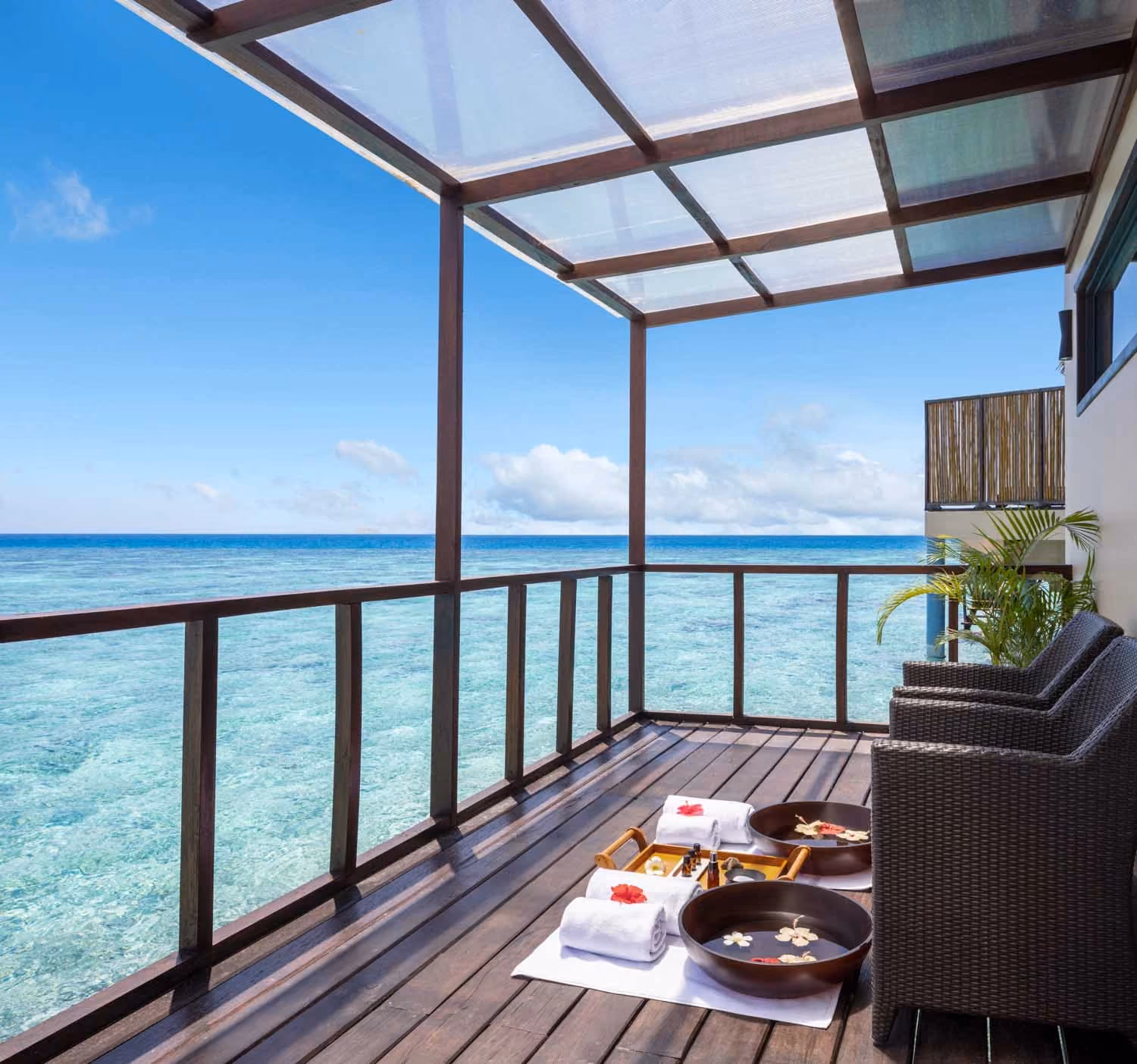 Spa treatment bowls on wooden deck over ocean water