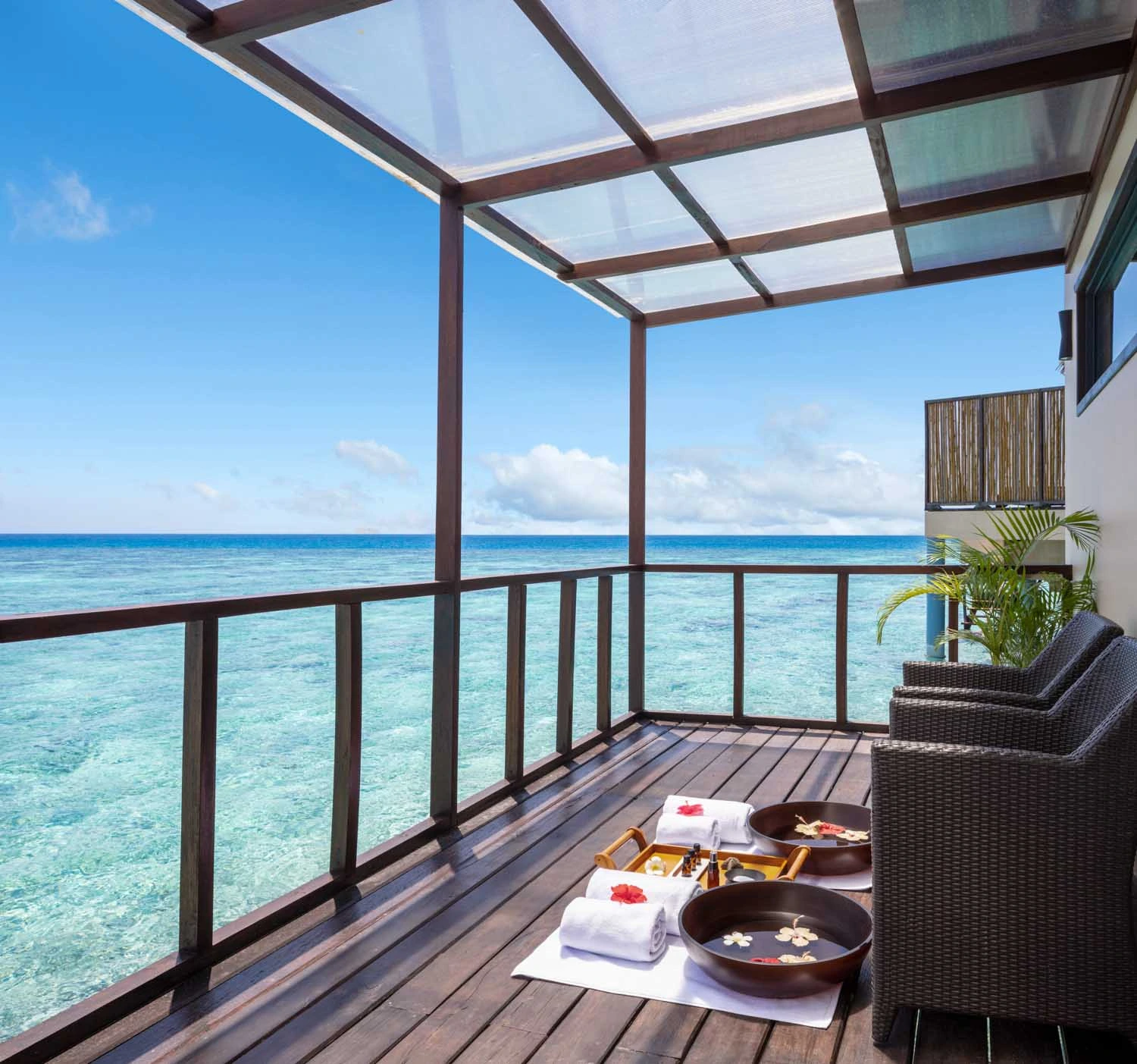 Spa treatment bowls on wooden deck over ocean water