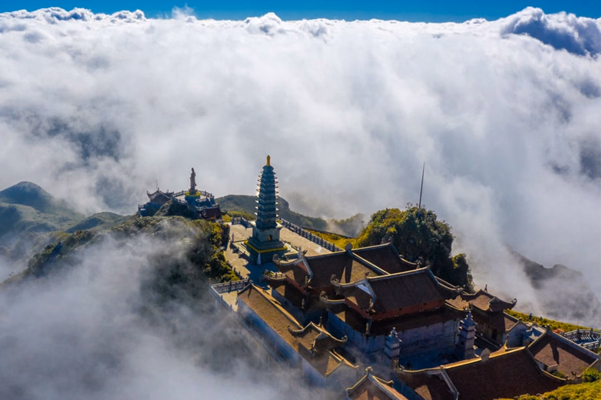 Buddhist temples on mountain peak in Sapa surrounded by clouds