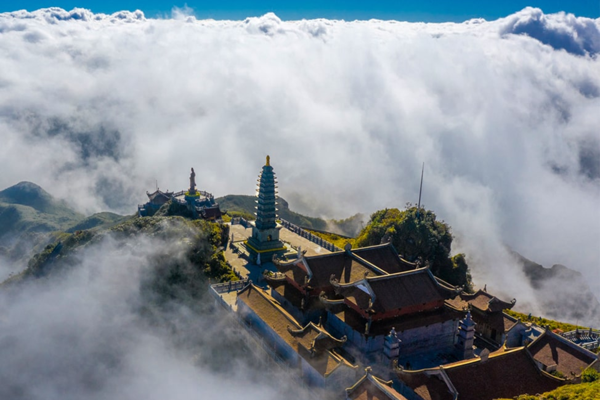Buddhist temples on mountain peak in Sapa surrounded by clouds