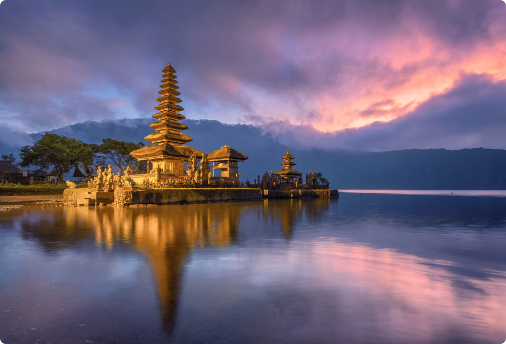 Golden temple reflected in still lake at sunset, Indonesia