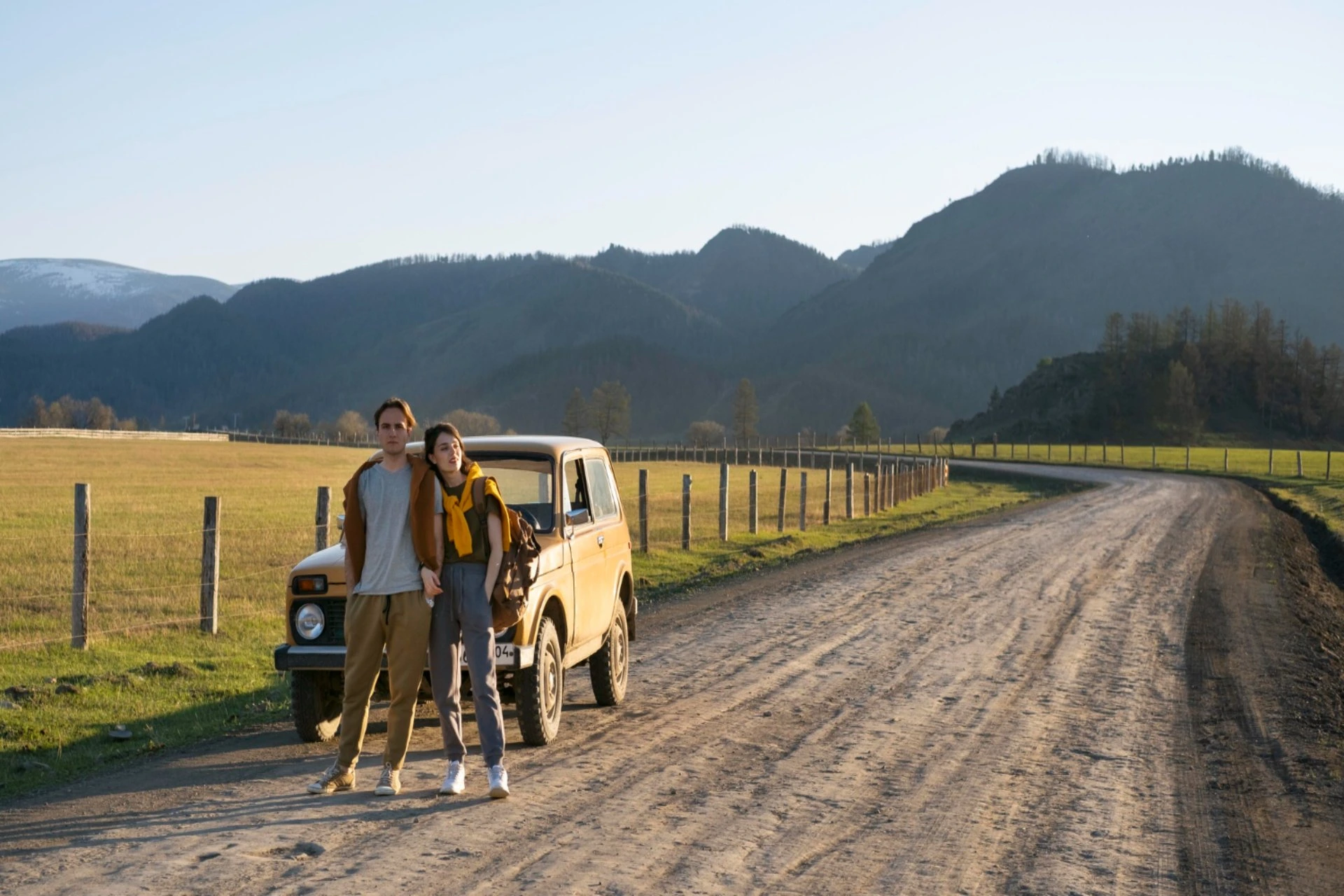 Couple on a scenic mountain road trip – New Zealand vs Switzerland travel