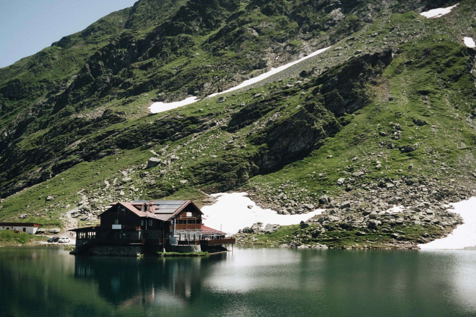Alpine lakeside lodge with mountain reflection – New Zealand vs Switzerland accommodation