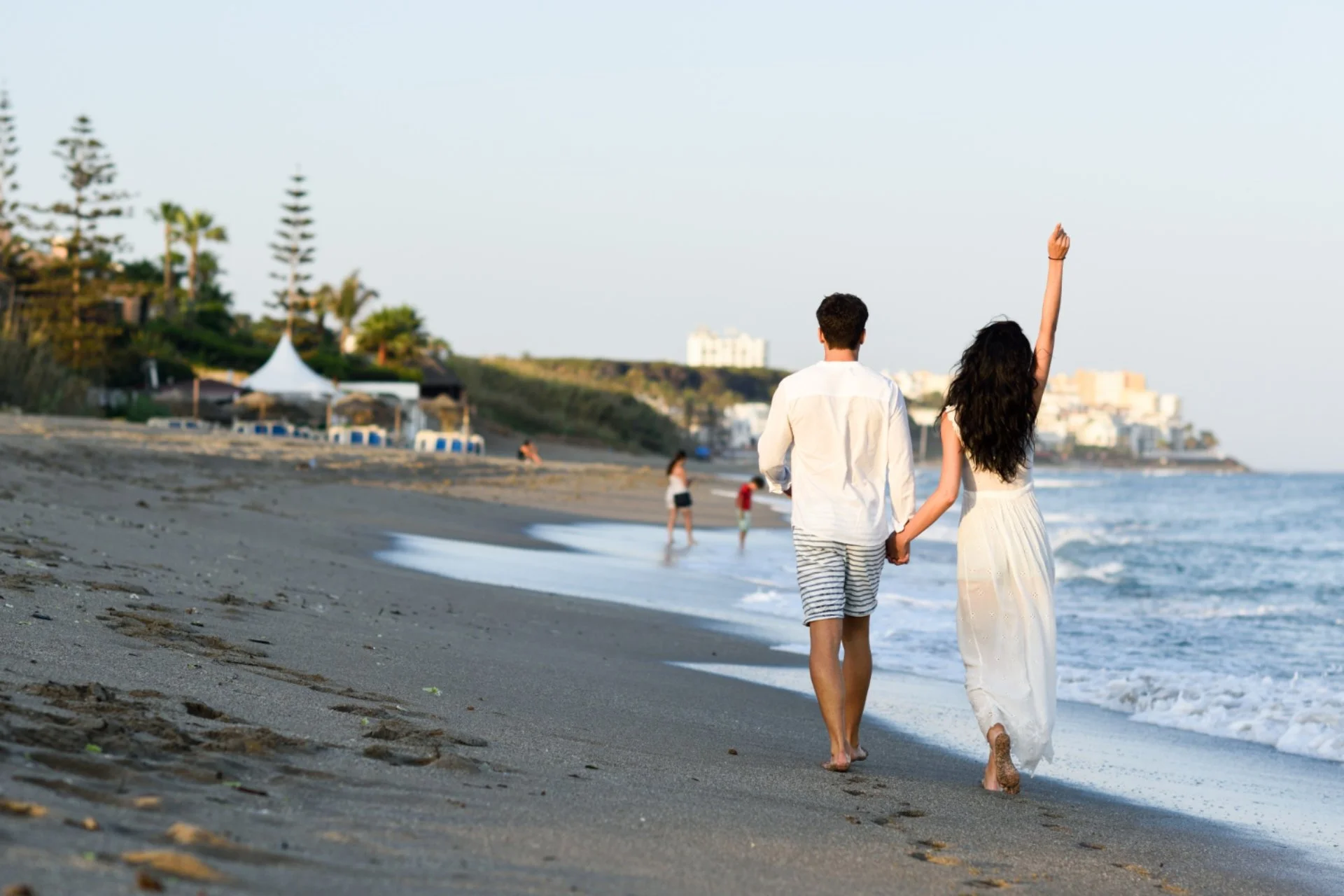Couple walking hand in hand on a beach in Thailand — best honeymoon destination to visit in June