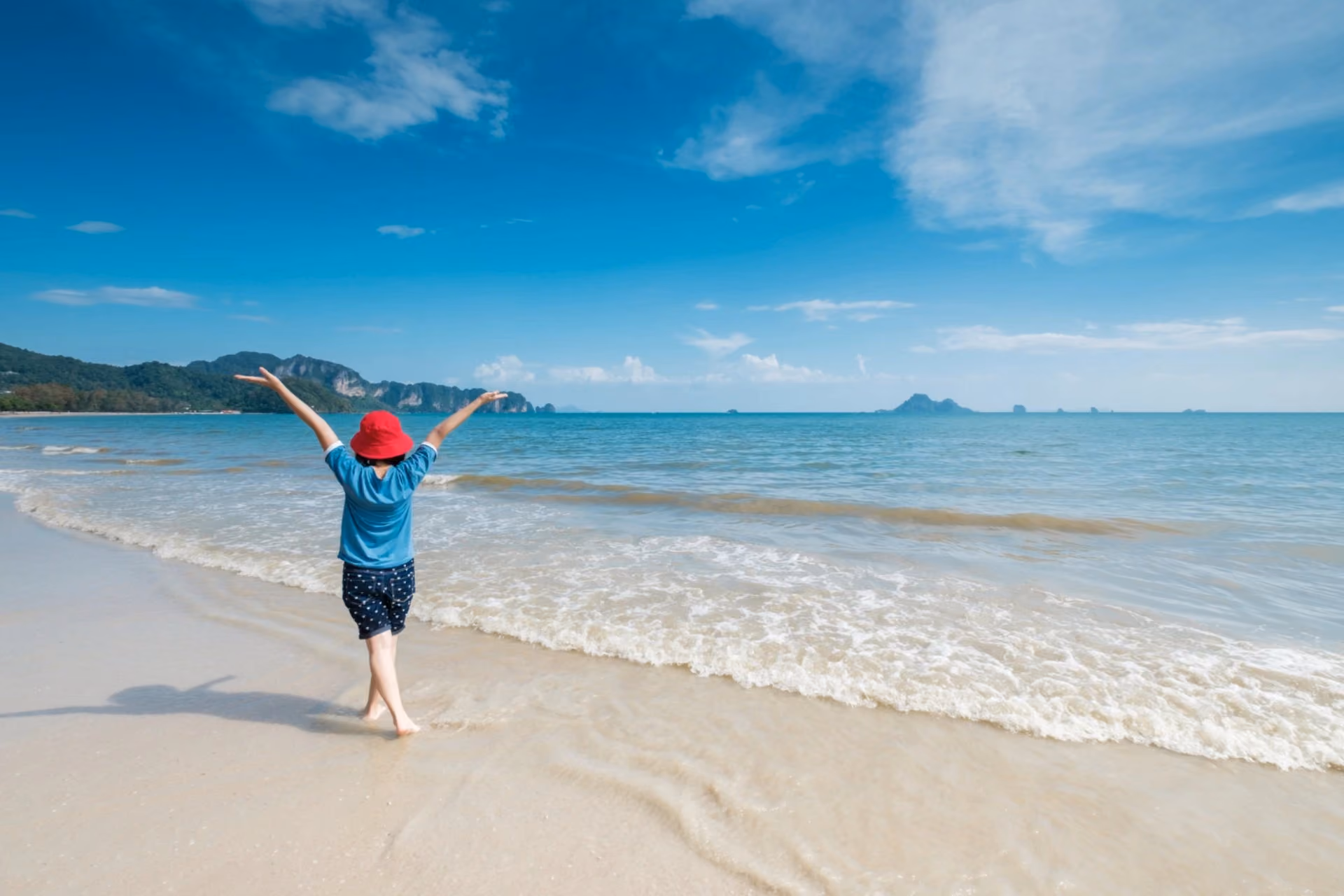 Traveller enjoying a beautiful tropical beach in October, representing the beach experience in Thailand vs Maldives with clear blue waters and white sandy shores.