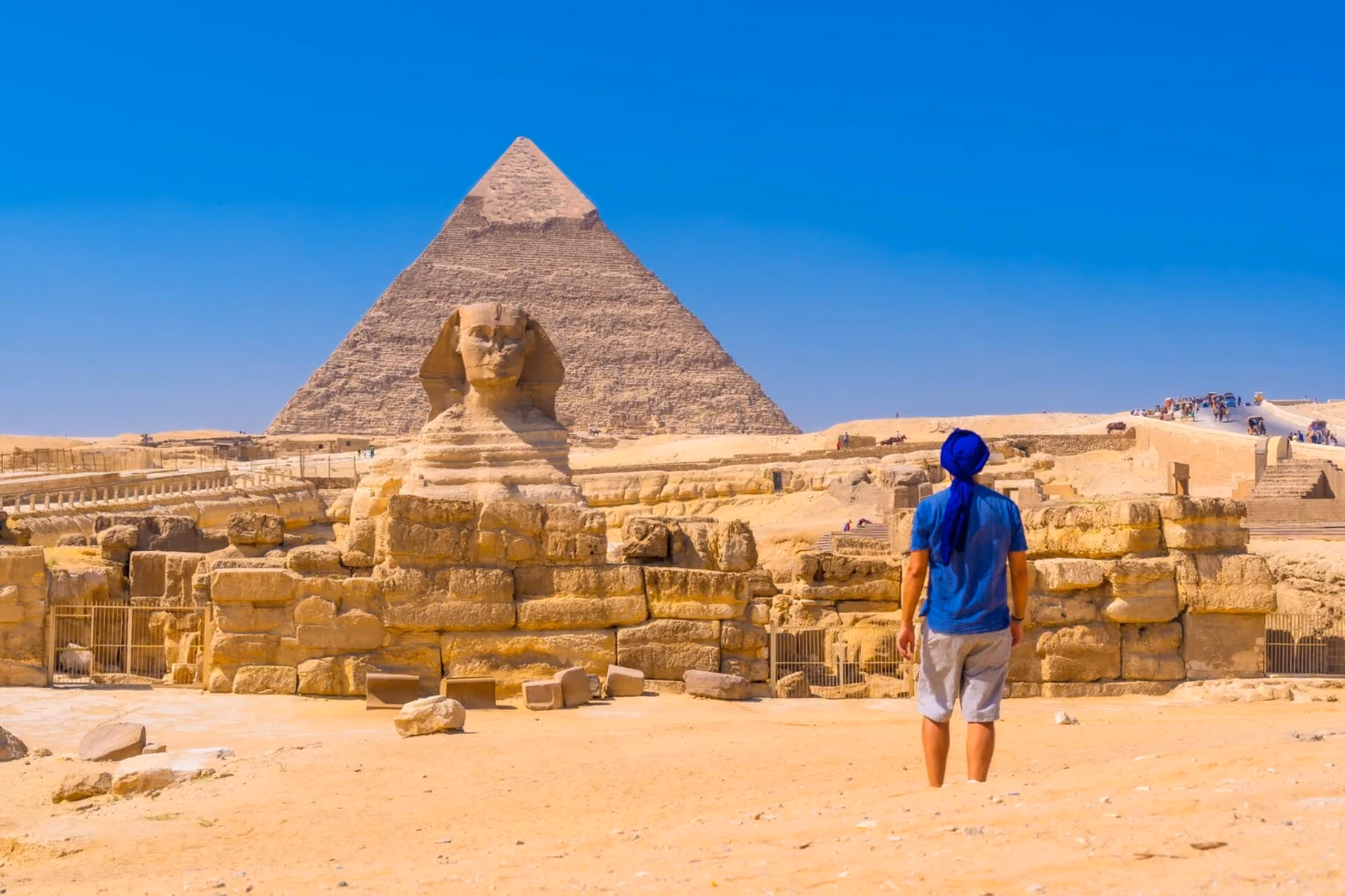 Traveler exploring the Great Sphinx and Pyramids of Giza under Egypt’s summer sun