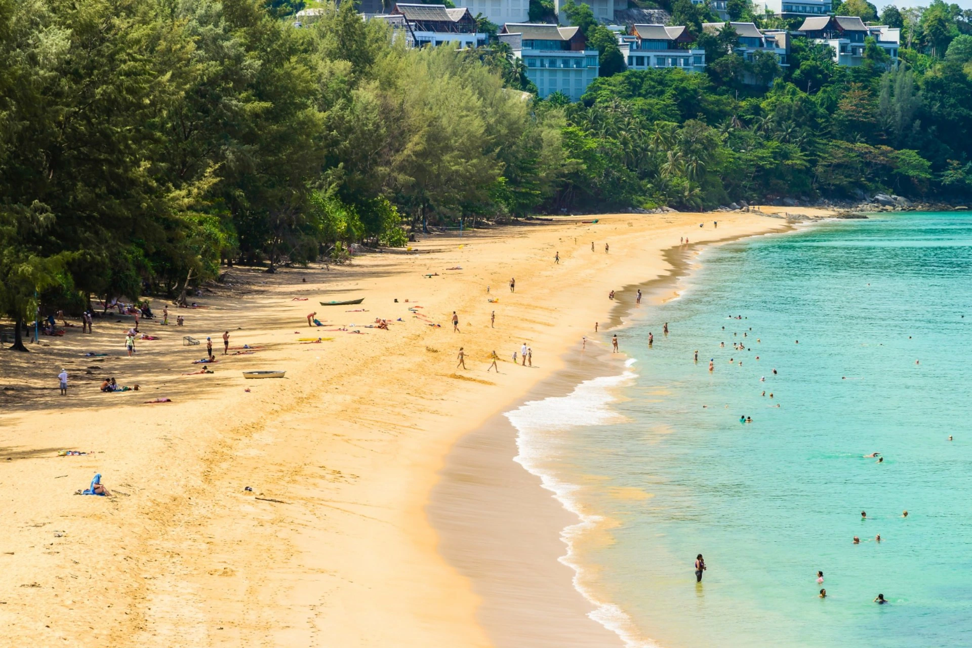 Tropical beach in Phu Quoc with turquoise water, golden sand, and lush green trees